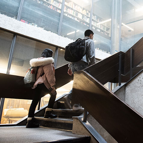 Un étudiant et une étudiante montent un escalier dans le Pavillon de la Bibliothèque McLennan